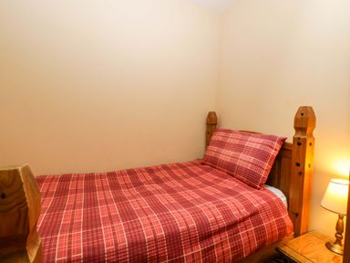 A bedroom with a bed and lamp at Dovecote Cottage in Corse near Gloucester