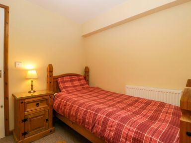 A bedroom with a single bed and a bedside table at Dovecote Cottage Corse near Gloucester
