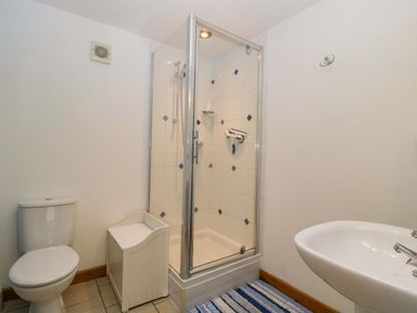 A bathroom with a shower, toilet, and sink at Dovecote Cottage in Corse near Gloucester