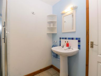 A bathroom with a sink and shelf at Dovecote Cottage in Corse near Gloucester