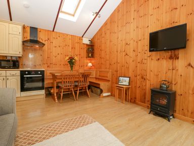 A kitchen with dining area and appliance at The Log Cabin in Corse near Gloucester