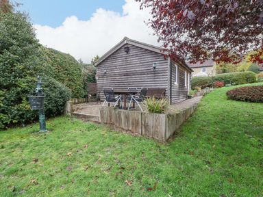 An outdoor area with a cabin, table, and chairs at The Log Cabin in Corse near Gloucester