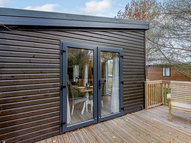A deck with double doors and outdoor seating at Somersby Spa in Louth