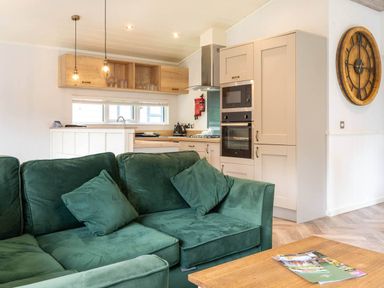 A living room with a couch and kitchen area at Wensleydale Aysgarth