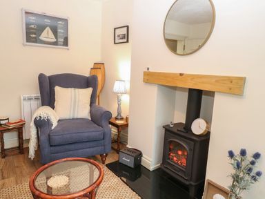 A living room with an armchair and fireplace at Beeble Cottage in Fakenham