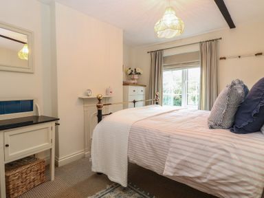 A bedroom with a bed and wardrobe at Beeble Cottage in Fakenham