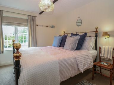 A bedroom with a bed and pillows at Beeble Cottage in Fakenham