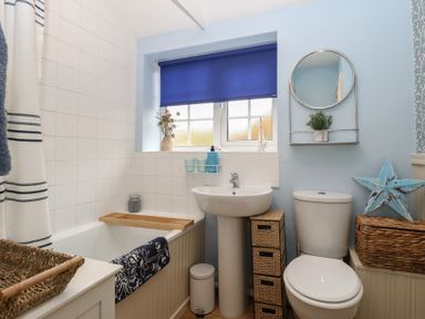 A bathroom featuring a bathtub, toilet, and sink at Beeble Cottage in Fakenham