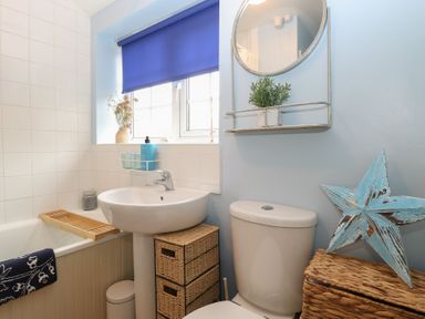 A bathroom with a sink and bathtub at Beeble Cottage in Fakenham