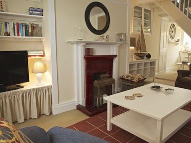 A living room with a fireplace and a television at St Leonards in Salcombe