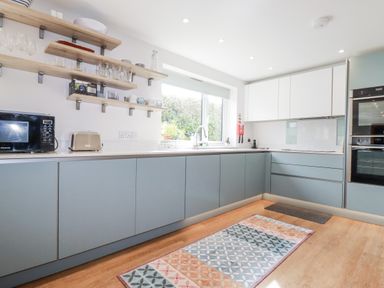 A kitchen with cabinets and appliances at Hillbre in Trevone