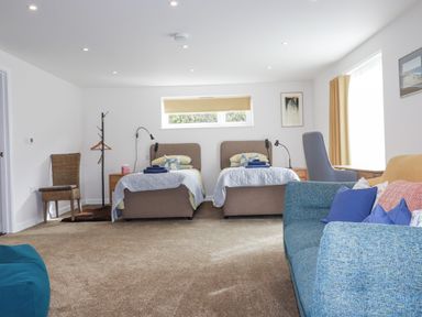 A bedroom with two beds and a sofa at Hillbre Trevone