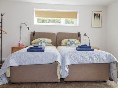 A bedroom with twin beds and bedside table at Hillbre in Trevone