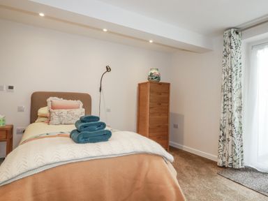 A bedroom with a bed and chest of drawers at Hillbre in Trevone