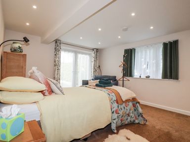 A bedroom with a bed and sofa at Hillbre in Trevone
