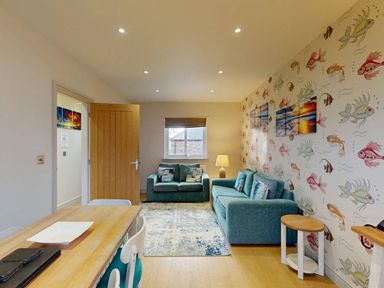 A living room with a sofa and dining table at Summerleaze Cottage 2 Spa Bude
