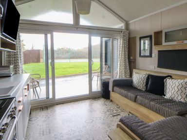 A living room with a sofa and television at The Family Pod in Swansea