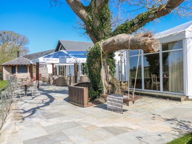 An outdoor area with a swing and seating at Glamping Pod 1 Oldwalls, Llanrhidian, Gower
