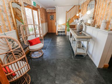 A hallway with a wooden table and a chair at Glamping Pod 1 Oldwalls, Llanrhidian, Gower