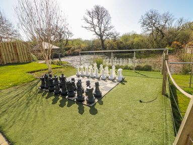 An outdoor chess set with black and white pieces at Glamping Pod 1 Oldwalls, Llanrhidian, Gower