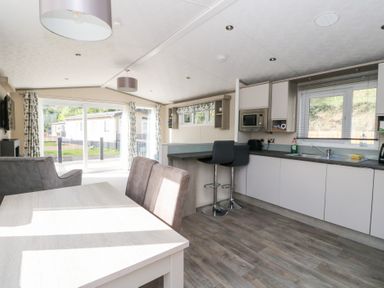 A kitchen with dining table and open layout at Altair Lodge