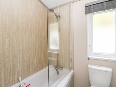 A bathroom with a bathtub, shower, and toilet at Altair Lodge