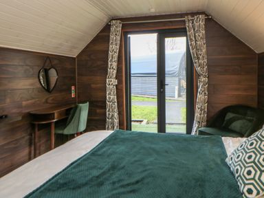 A bedroom with a bed and desk at Garden lodge 3 in Swansea
