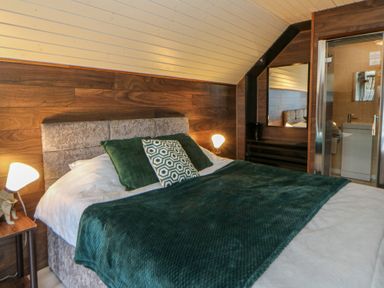 A bedroom with a bed and attached bathroom at Garden lodge 3 Swansea