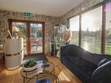A lobby with a sofa and display case at Garden lodge 3 Swansea