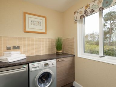 A laundry room with a washing machine and towels at The Allensford in Slaley