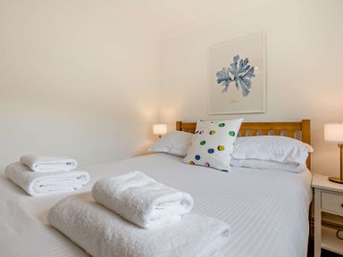 A bedroom with towels on the bed at Kernow Nook Spa in Perranporth