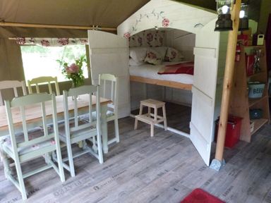 A dining area with a table and chairs beside a bed at Ceri in Newcastle Emlyn