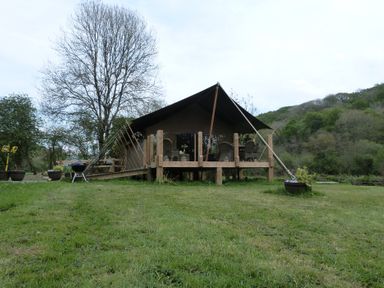 A tent structure with a deck and chairs at Ceri in Newcastle Emlyn