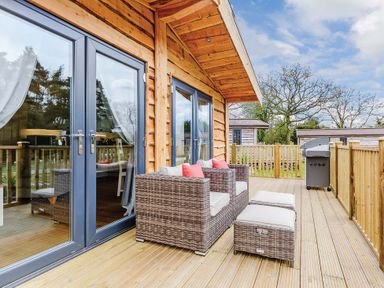 A deck with seating and sliding doors at Typhoon Lodge in Winchester