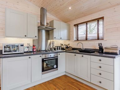 A kitchen with cabinets and appliances at Typhoon Lodge in Winchester