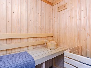 A sauna with wooden bench and bucket at Typhoon Lodge in Winchester