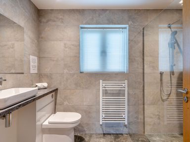A bathroom with toilet, sink, mirror and shower at Tranquillity 3 Warton near Carnforth
