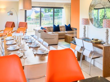 A living room with a dining table and sofa at Nan's House Spa in Marhamchurch