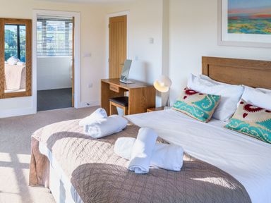 A bedroom with a bed and desk at Nan's House Spa in Marhamchurch