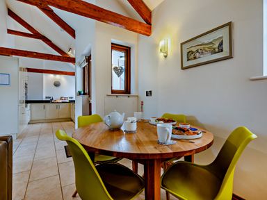 A kitchen with a dining table and chairs at Barley Park Marhamchurch