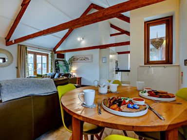 A dining room with a table set for breakfast at Barley Park in Marhamchurch