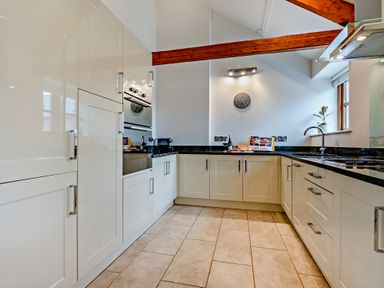 A kitchen with cabinets, sink, and oven at Barley Park in Marhamchurch