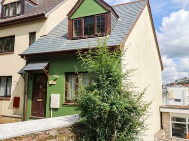 A house with a green wall and brown door at The Gables in Teignmouth