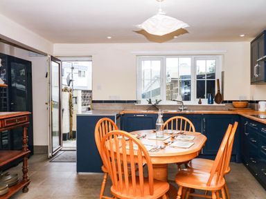 A kitchen with a table and chairs at The Gables in Teignmouth