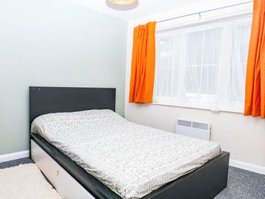 A bedroom with a bed and window at The Gables in Teignmouth