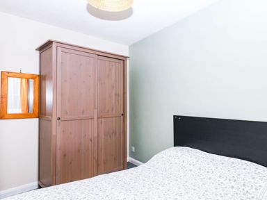 A bedroom with a wardrobe and a mirror at The Gables in Teignmouth