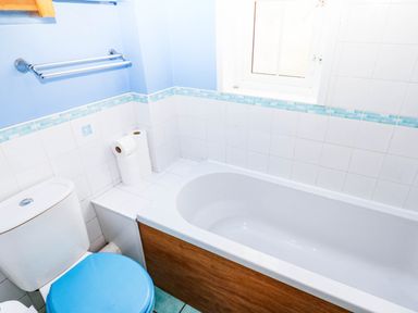 A bathroom with a bathtub and toilet at The Gables in Teignmouth