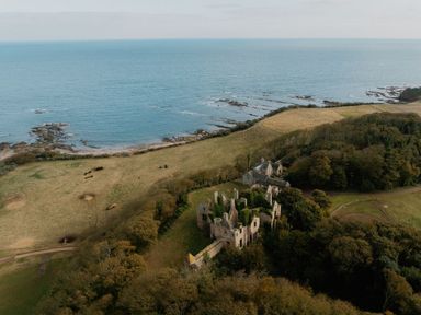 A landscape view of coastal ruins near the ocean at The Weir North Berwick
