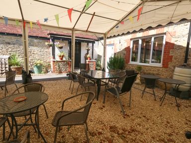 An outdoor seating area with tables and chairs at The Old Barn in Stourton Caundle near Stalbridge