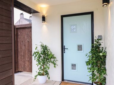 An entrance area with a blue door and plants at Pistyll Ddu in Brynsiencyn near Llanfairpwllgwyngyll